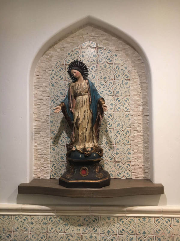 decorative-religious-statue-in-wall-alcove Religious statue displayed in a decorative alcove with patterned tile background.